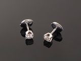 a pair of diamond stud earrings on a black surface