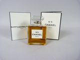 Flacon et coffret du parfum Chanel n° 5 posés sur une surface blanche