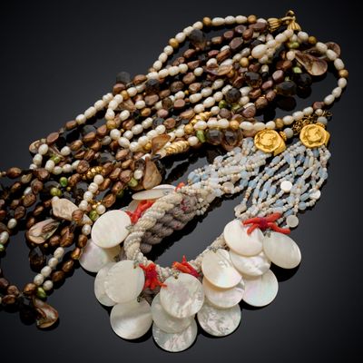 plusieurs colliers composés de coquillages et de perles sur un fond noir