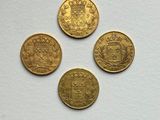 four different types of gold coins sitting on top of a white surface