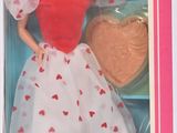 une poupée dans une boîte rose ornée d'un cœur rouge