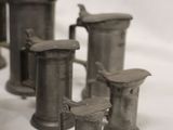 a lot of old pewware on a white table