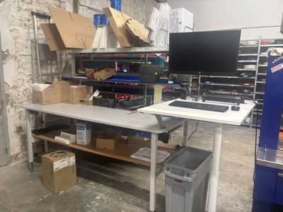 un bureau sur lequel se trouve un ordinateur, dans un entrepôt
