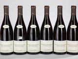 six bouteilles de vin sont alignées sur une table