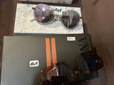 une paire de lunettes de soleil posée sur une boîte à côté d'une autre paire de lunettes de soleil