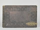 un vieux livre posé sur une table blanche à côté d'un mur blanc