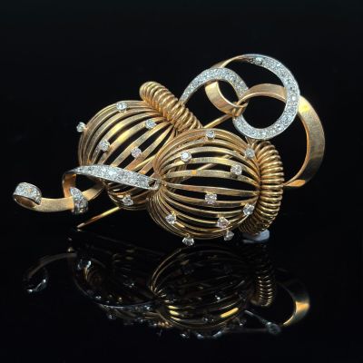 a pair of gold and diamond earrings on a black surface