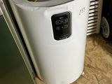un chauffe-eau posé au sol à côté d'un réfrigérateur
