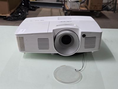 un projecteur blanc posé sur une table en verre