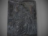 an image of a black plaque with a woman sitting on a bench