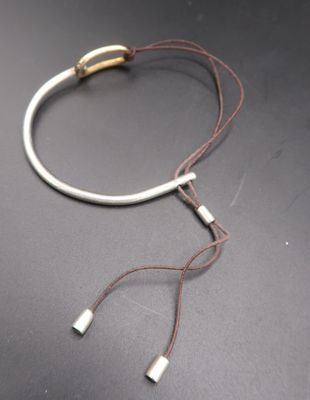 a white bracelet with two silver beads on it