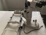 une photo d'un microscope posé sur une table près d'une fenêtre