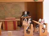 a small doll house with a red roof and wooden furniture