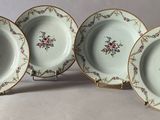 trois assiettes ornées de motifs floraux sont posées sur une surface blanche