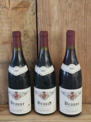 three bottles of wine sit on a wooden shelf in front of a wooden wall