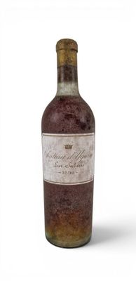 an old bottle of wine sitting on top of a white surface