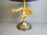 une statue de dragon en or posée sur un socle noir
