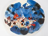 a plate with a painting on it on a white surface