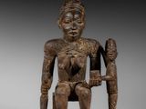 une statue en bois représentant un homme tenant un enfant dans ses bras