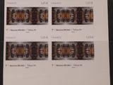 quatre timbres représentant différents types de bouteilles, posés sur une table