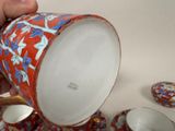 a person holding a cup and saucer over a plate