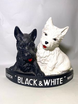 deux figurines de chiens en noir et blanc assises l'une à côté de l'autre