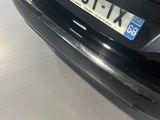 the rear end of a black car with a license plate on it