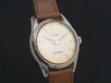 une montre avec un bracelet en cuir marron sur fond noir
