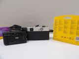 two cameras sitting next to each other on a table