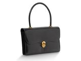 un sac à main en cuir noir muni d'un fermoir doré sur la poignée
