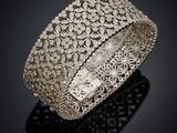 gros plan d'un bracelet en argent sur une surface noire