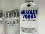 three bottles of vodka are lined up on a white surface