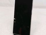the back of a black cell phone sitting on top of a white table