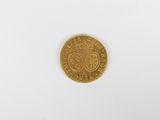 a gold coin on a white surface with a white background