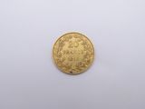gros plan d'une pièce d'or sur une surface blanche