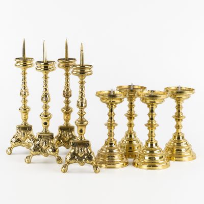 six brass candlesticks and a candle holder on a white background