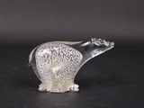 une figurine en verre représentant un ours polaire posée sur un support noir