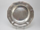 silver plate with scalloped edge on stand on white background