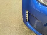 a close up of a blue car with a hole in the front of it