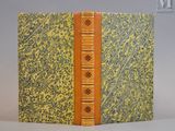 un vieux livre à la couverture jaune posé sur une table