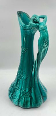 a green vase with a woman on it on a white background