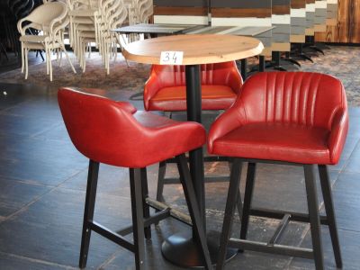trois chaises rouges disposées autour d'une table au milieu d'une pièce