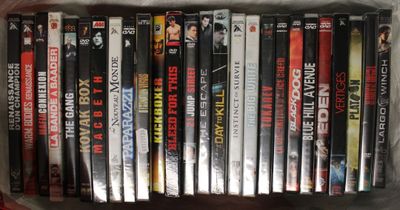 beaucoup de DVD dans un sac en plastique posé sur une table