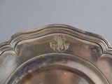 an antique silver plate with a monogram on the rim