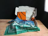 a box that has a scarf and other items in it on a table