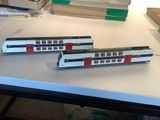 two model trains sitting on a table next to boxes