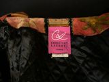 a close up of a black jacket with a pink label on it