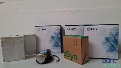 trois boîtes contenant des appareils électroniques posées les unes à côté des autres sur une table