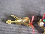 a small gold brooch with a violin on it