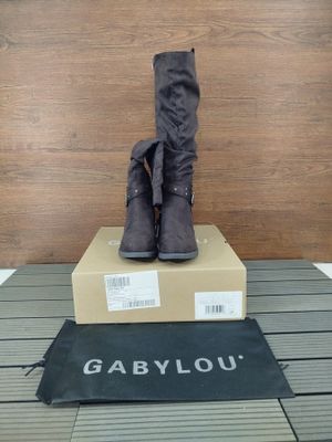 les bottes sont posées sur une boîte en carton, posée elle-même sur un plancher en bois